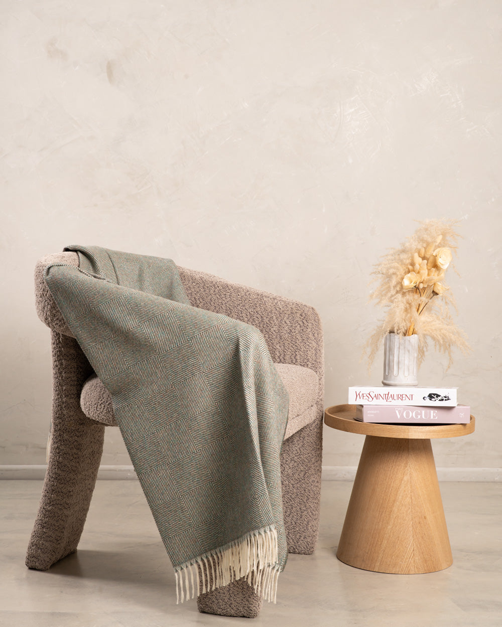 a alpaca blanket in a grey chair in a emty room 