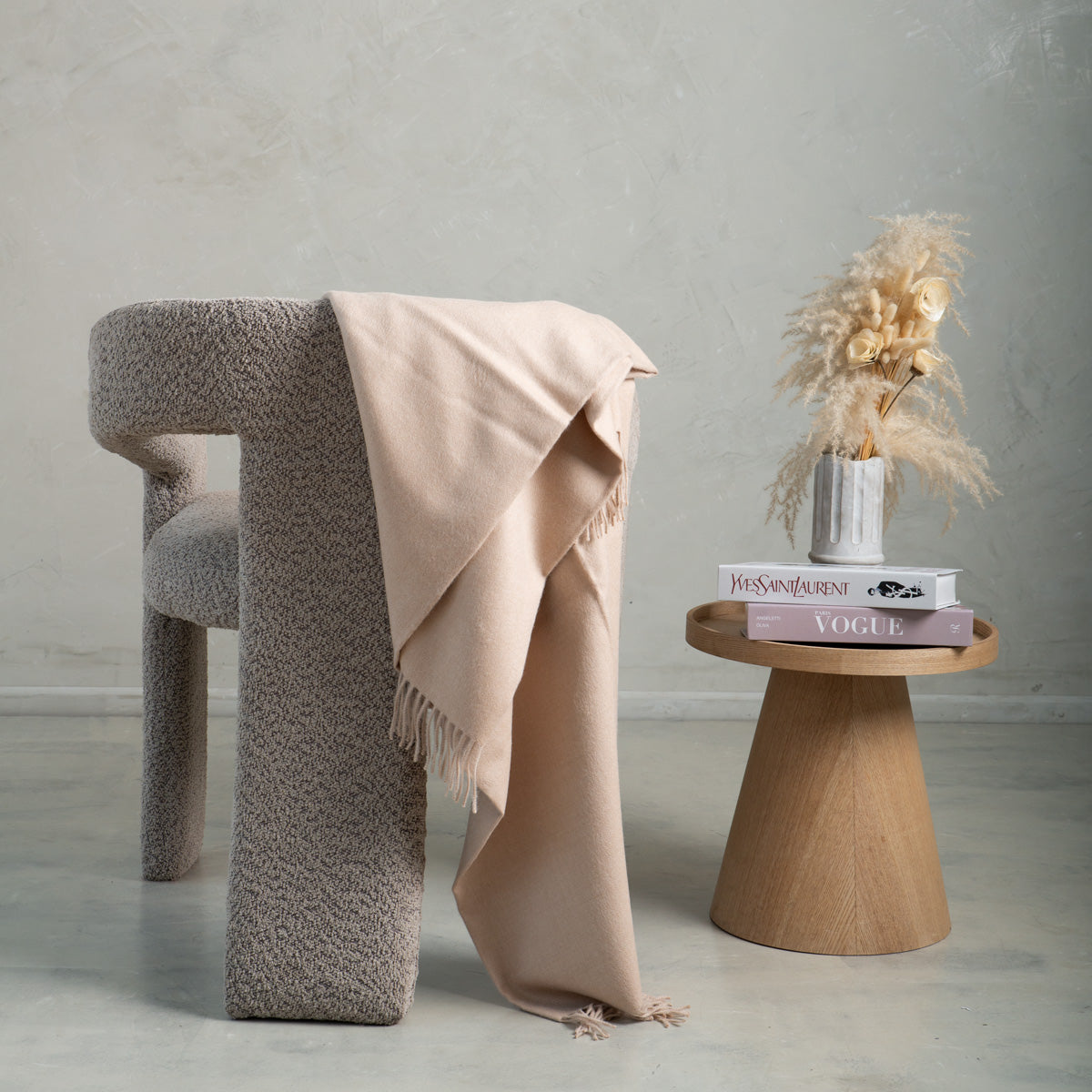 dusty pink alpaca blanket in a  grey chair 