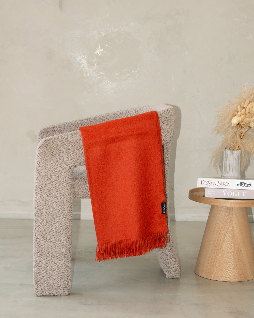 alpaca orange banket in a grey chair 