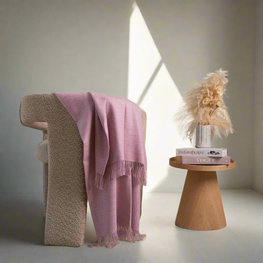 pink alpaca blanket in a grey chair 